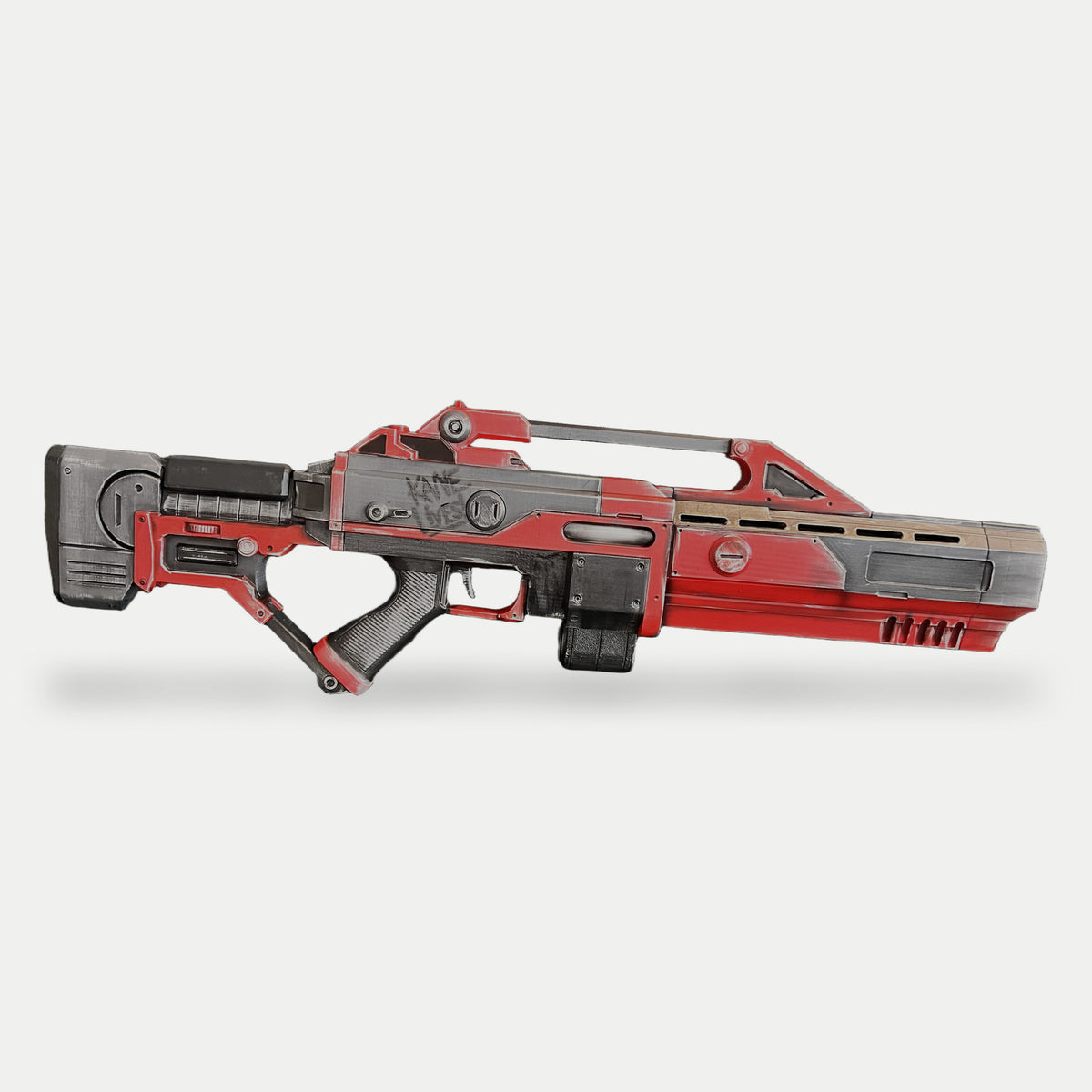Left side of the red, black and gray Command & Conquer Renegade AR-70 Raptor Nod prop, with Kane Lives! graffiti and the muzzle pointing right.