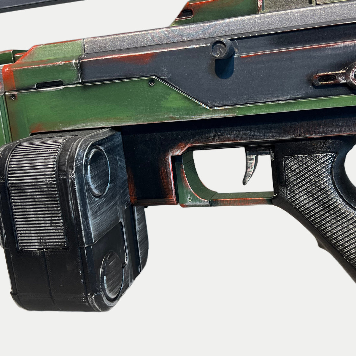 Black ribbed drum magazine, trigger guard and textured grip on the painted AR-70 Raptor prop.