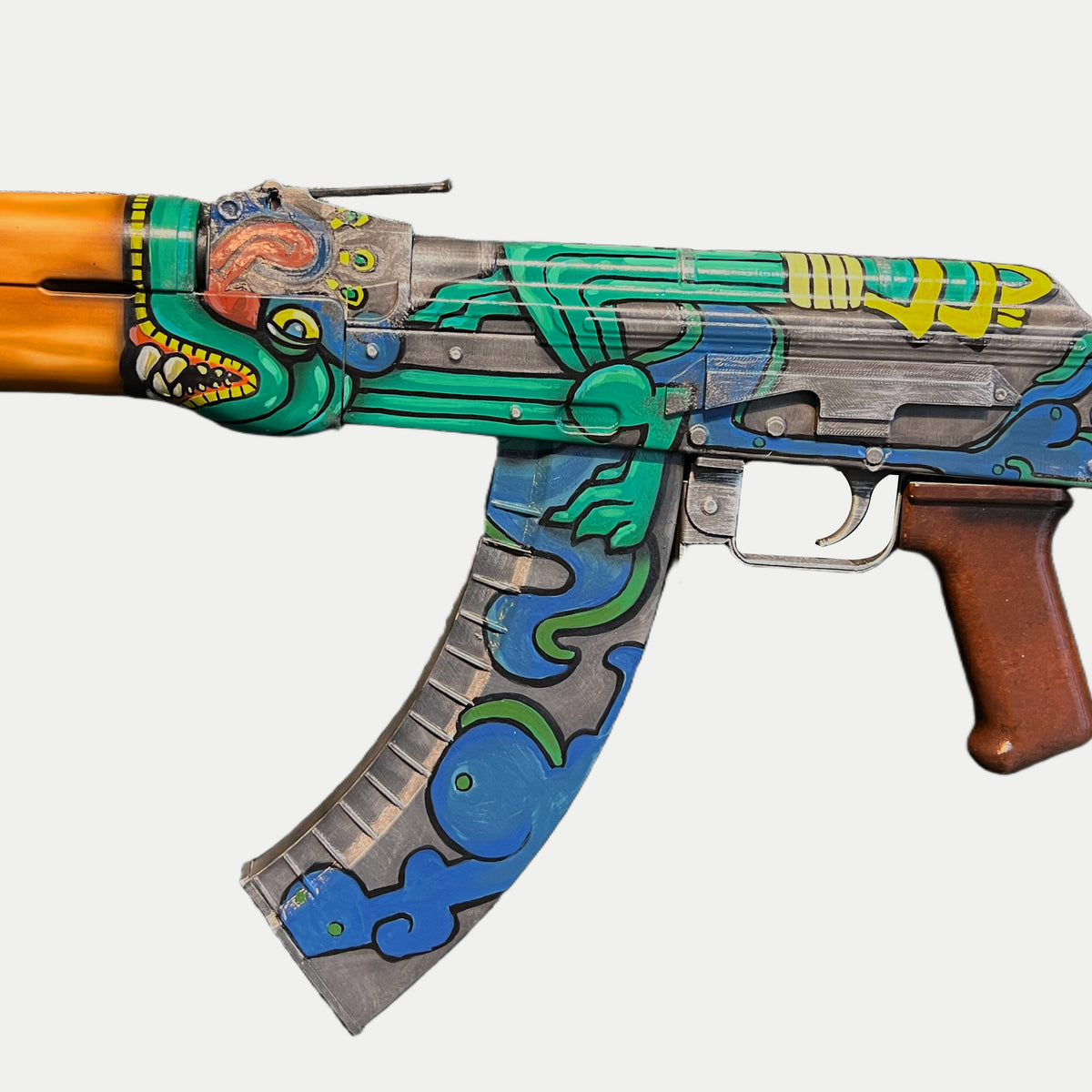 Fire Serpent artwork on the opposite receiver side, with the green body and claw above blue and green cloud shapes on the curved magazine.