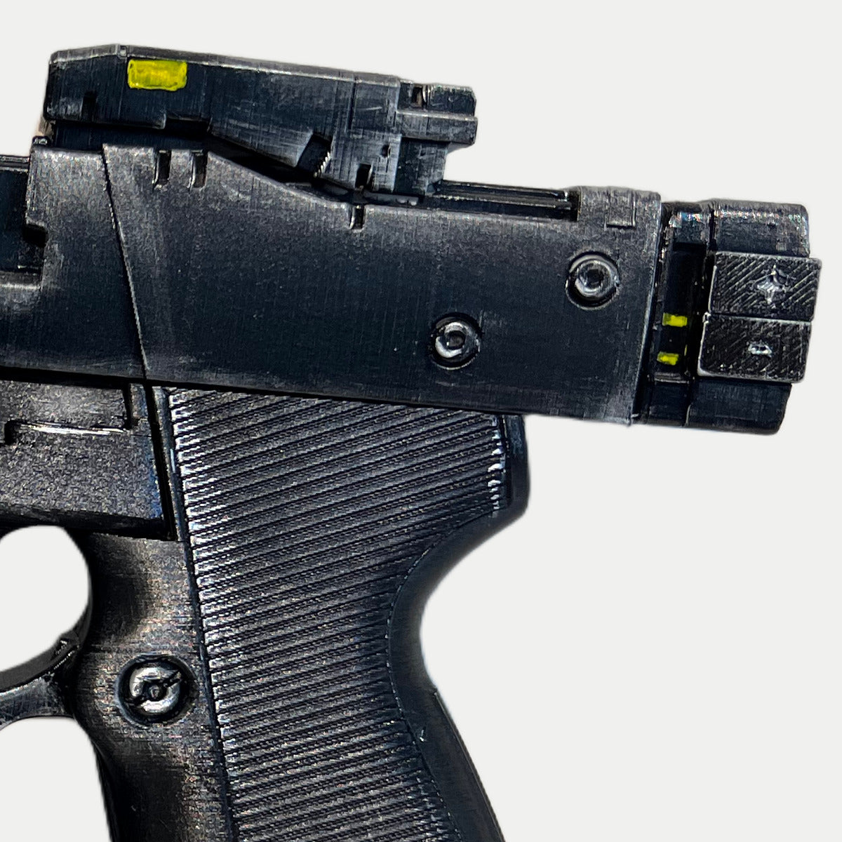Close-up of the yellow sight marks, silver-drybrushed edges, screw details and ribbed grip on the painted Cyberpunk Pariah pistol prop.