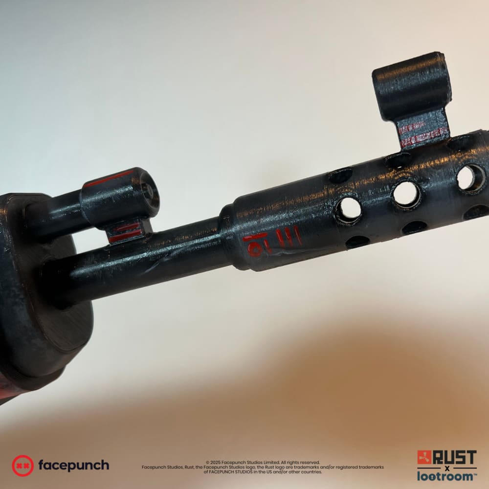 Muzzle end of the Alien Red AK prop with red alien markings on the black gas block