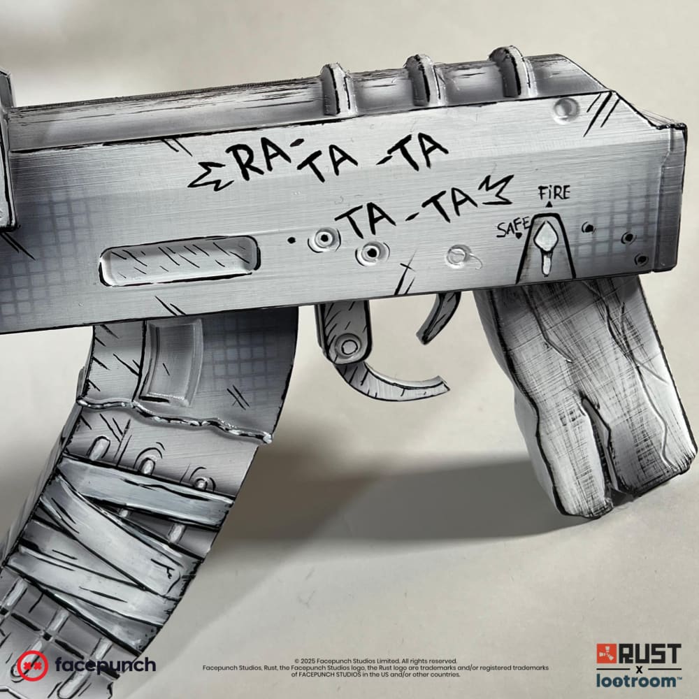 Close-up of the Comics AK receiver, RA-TA-TA and TA-TA hand-lettered beside the SAFE and FIRE marks.