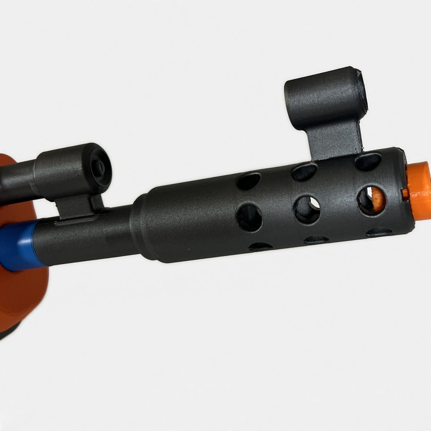 Close-up of the Rust AK muzzle brake and front sight, black with the orange ring at the barrel tip