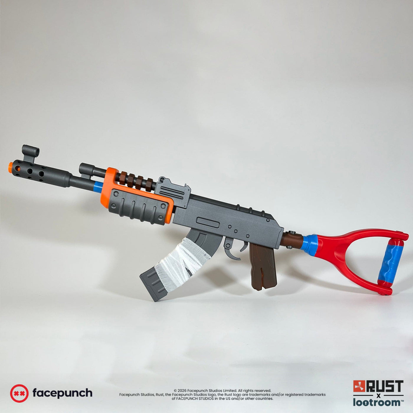 Rust AK prop replica from the opposite side, showing the orange handguard and wood-effect grips