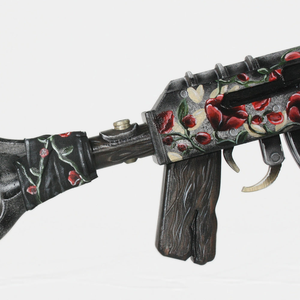 Close-up of the Eltk AK receiver and curved magazine, red roses running across the worn black finish.