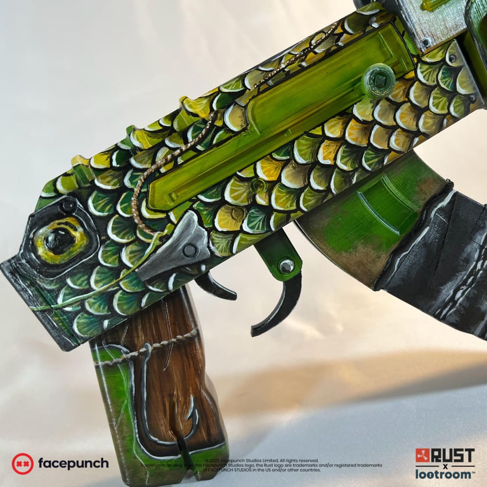 Close-up of the Fish AK receiver, the painted eye above the hook and line on the wood-look grip.