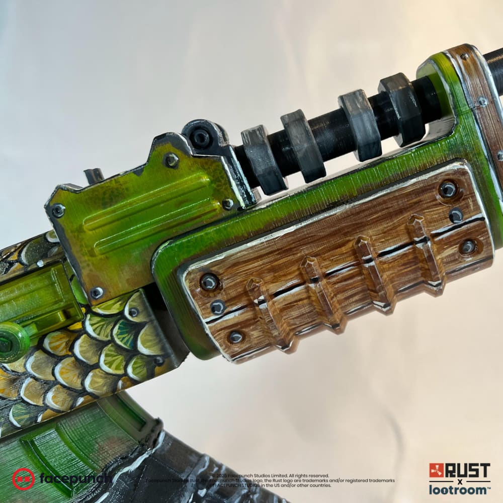 Close-up of the Fish AK handguard, wood-look planks with rivets beside the green dust cover.