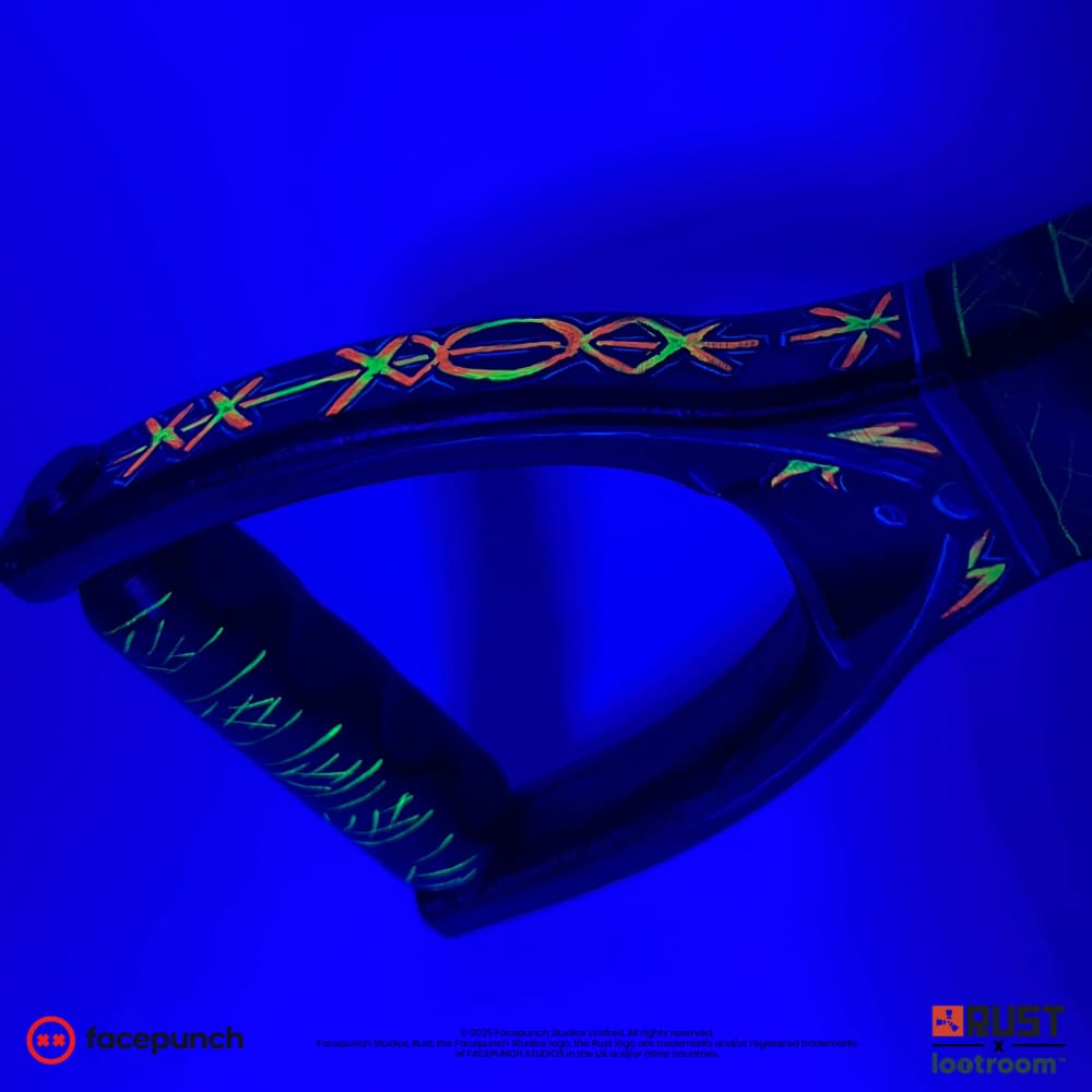 Close-up of the From Hell AK stock loop under UV light, its glyphs glowing against the dark.