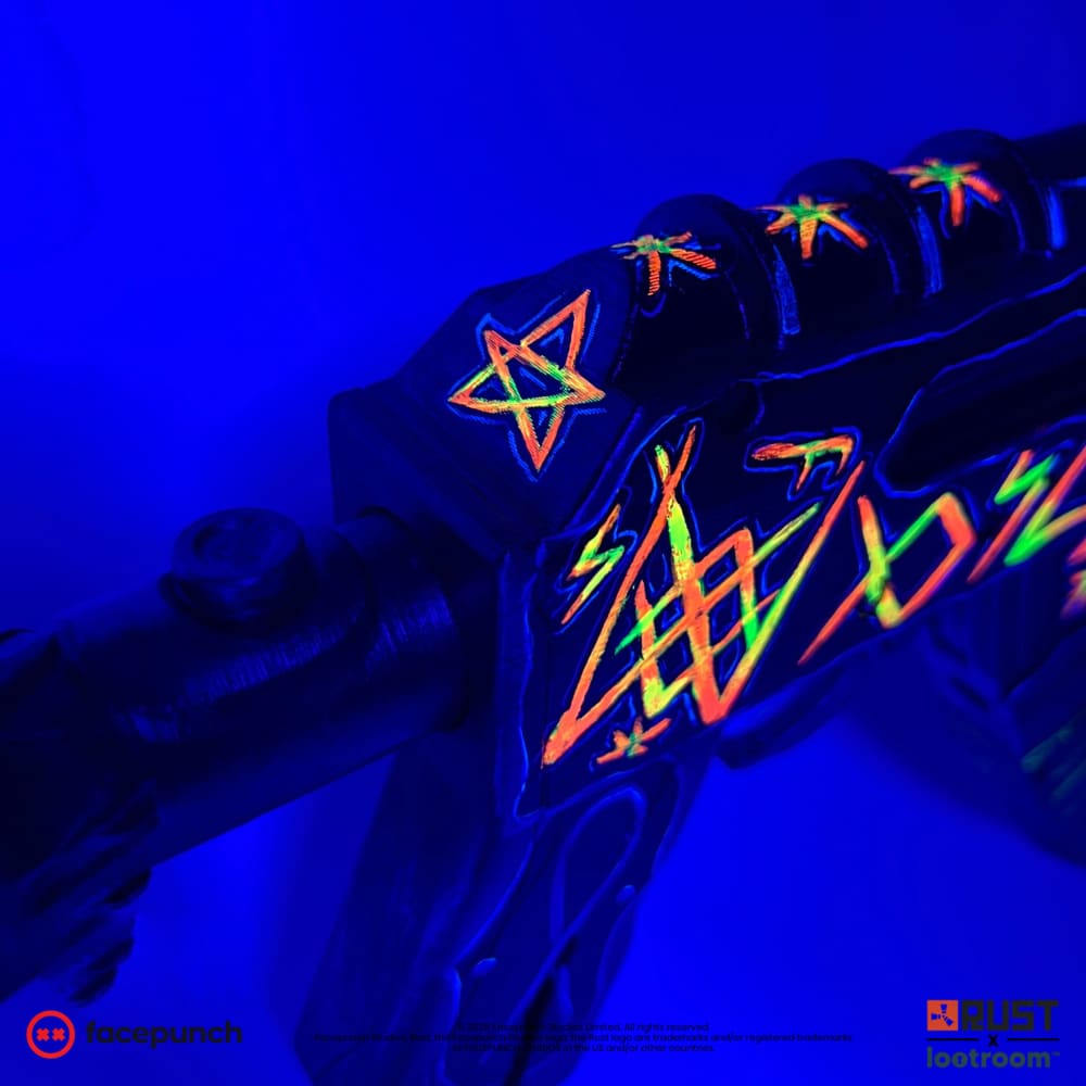 Close-up of the From Hell AK pentagram under UV light, glowing orange and green on the receiver.