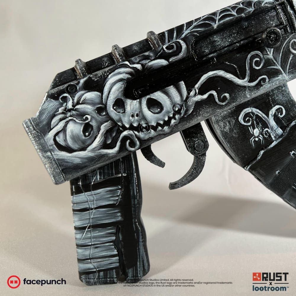 Close-up of the Ghost Halloween AK receiver, grinning carved pumpkins painted in white.
