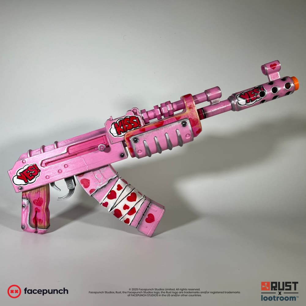 Rust Kiss AK prop from the left, metallic pink with KISS and YES speech bubbles and a heart-covered magazine