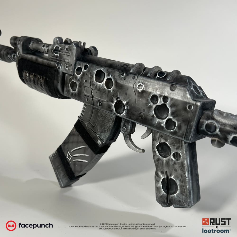 Close-up of the Lunar AK receiver and magazine, deep craters rimmed light over grey rock.