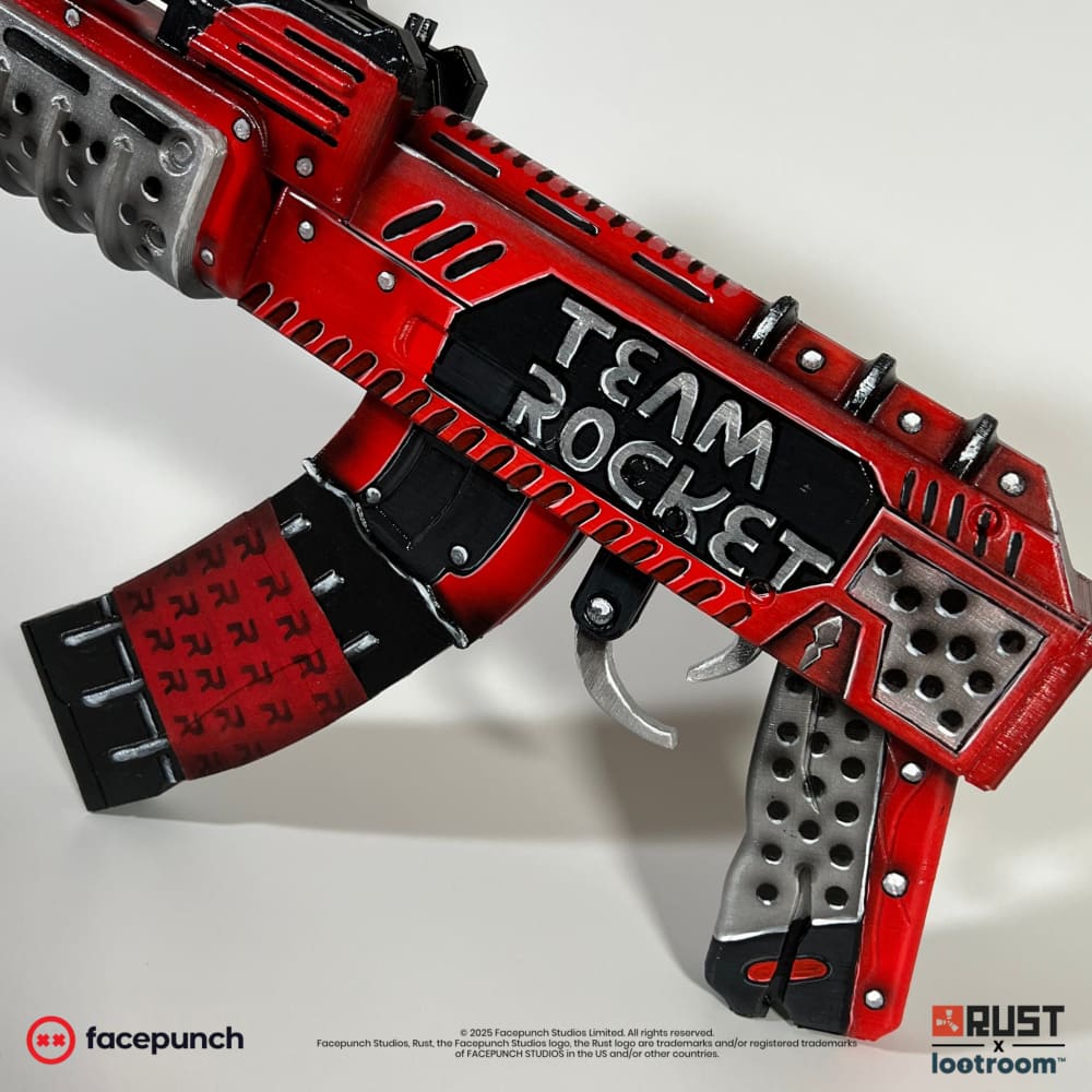 Rust Team Rocket AK prop at an angle, the handwritten TEAM ROCKET lettering on the receiver.