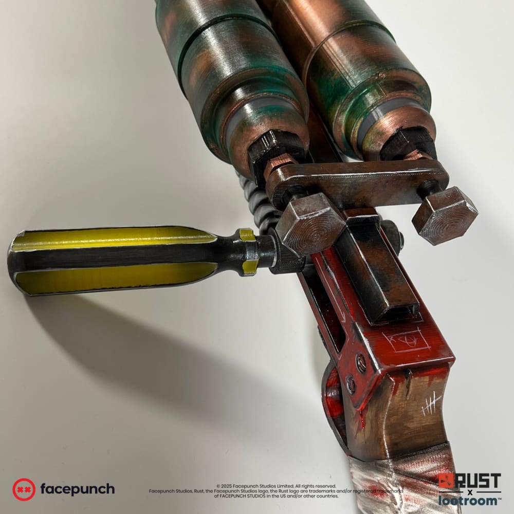 Detail of the Rust Double Barrel prop with the red frame, the yellow screwdriver-style lever and the white tally marks painted on the wood-look grip