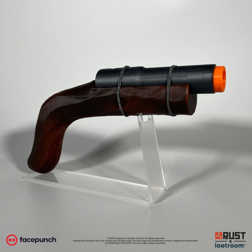 Rust Eoka prop on the optional acrylic stand, deep red-brown wood-look grip and near-black pipe barrel