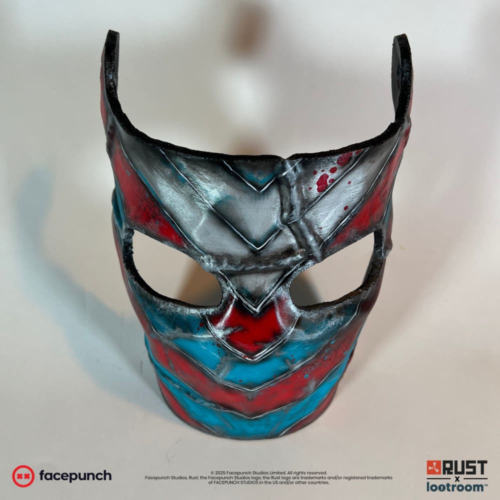 Rust IOK facemask prop head-on, paint rubbed back to bare metal on the ridges