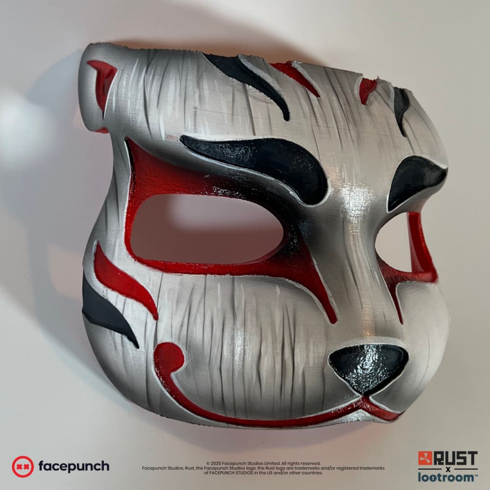 Rust Mendo kitsune facemask prop from the other side, with the black nose and red mouth line