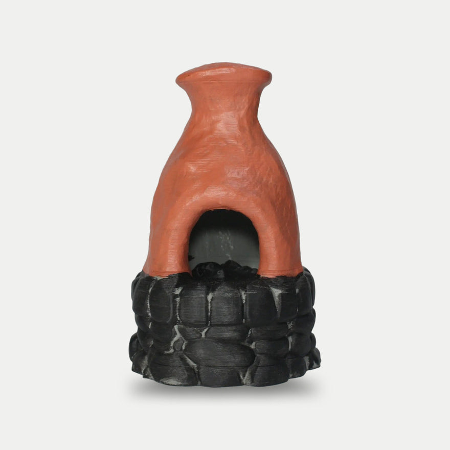 Rust Furnace desk prop, burnt-orange clay chimney on a stacked stone base, hand-painted in Bavaria