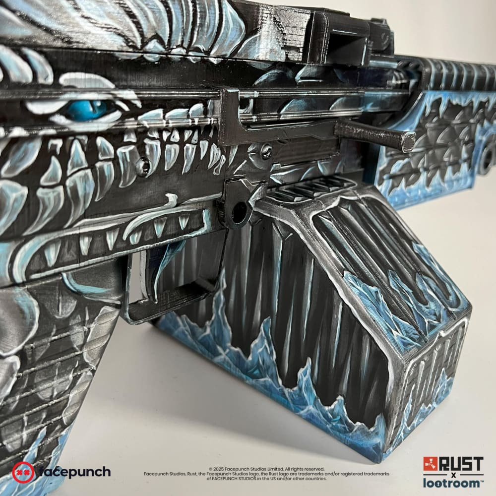 Close-up of the Frost M249 dragon head above the trigger, teal tongue and bared teeth.