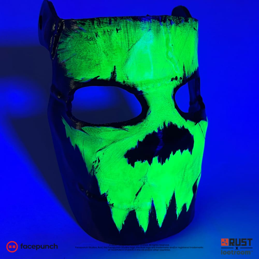 Rust Glowing Skull facemask glowing under blacklight at an angle, only the green skull visible