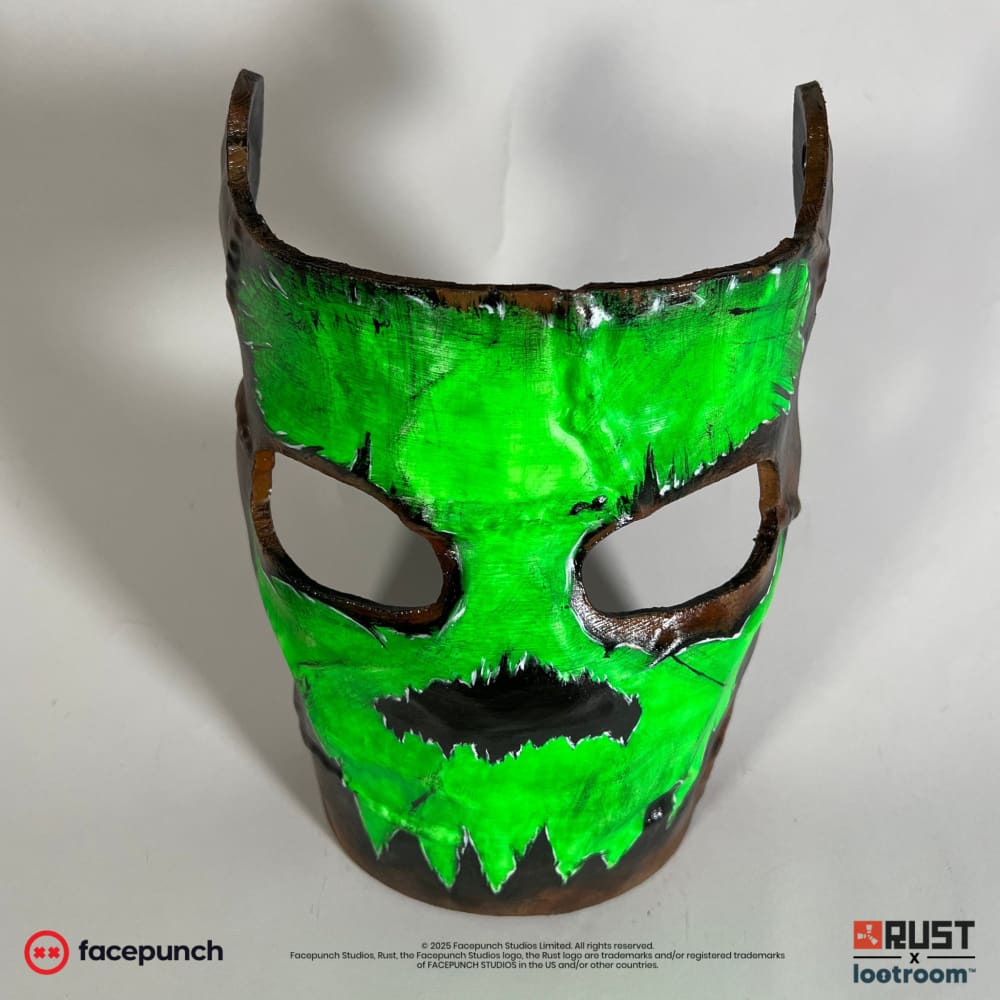 Rust Glowing Skull facemask head-on, green skull with black eye sockets and a jagged row of teeth