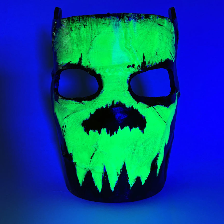Rust Glowing Skull Facemask under UV light, the green skull glowing while the mask goes dark