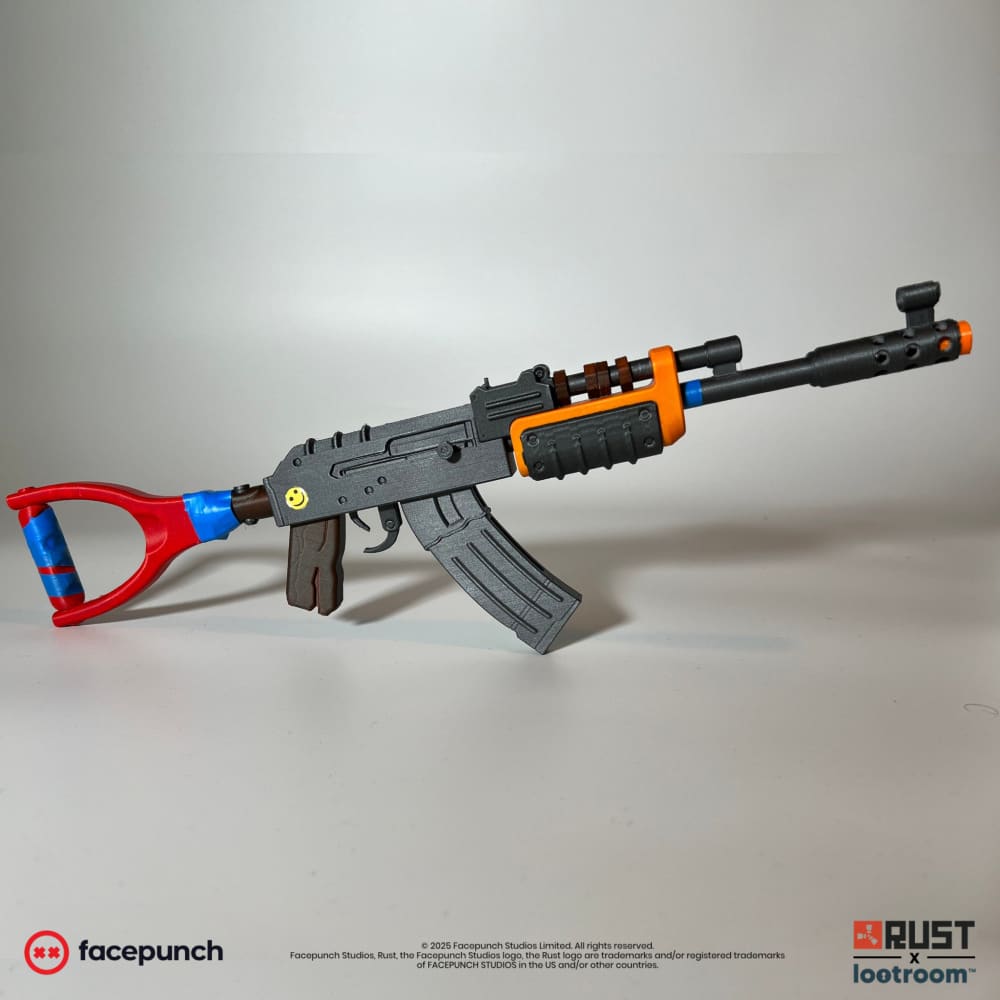 Rust Mini AK prop, 40cm miniature with grey receiver, red stock with blue tape and the yellow smiley sticker