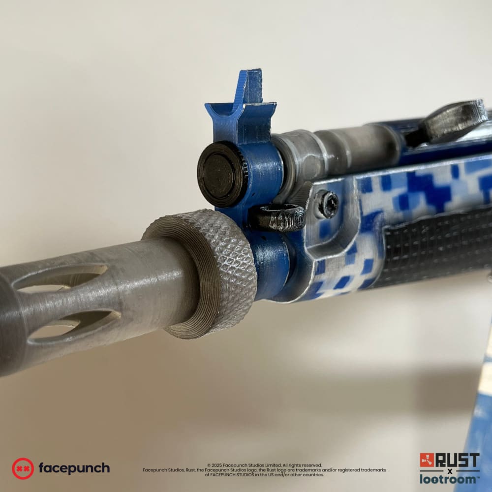 The muzzle end of the Rust Sinks MP5 prop, silver barrel with a knurled collar and the blue front sight.