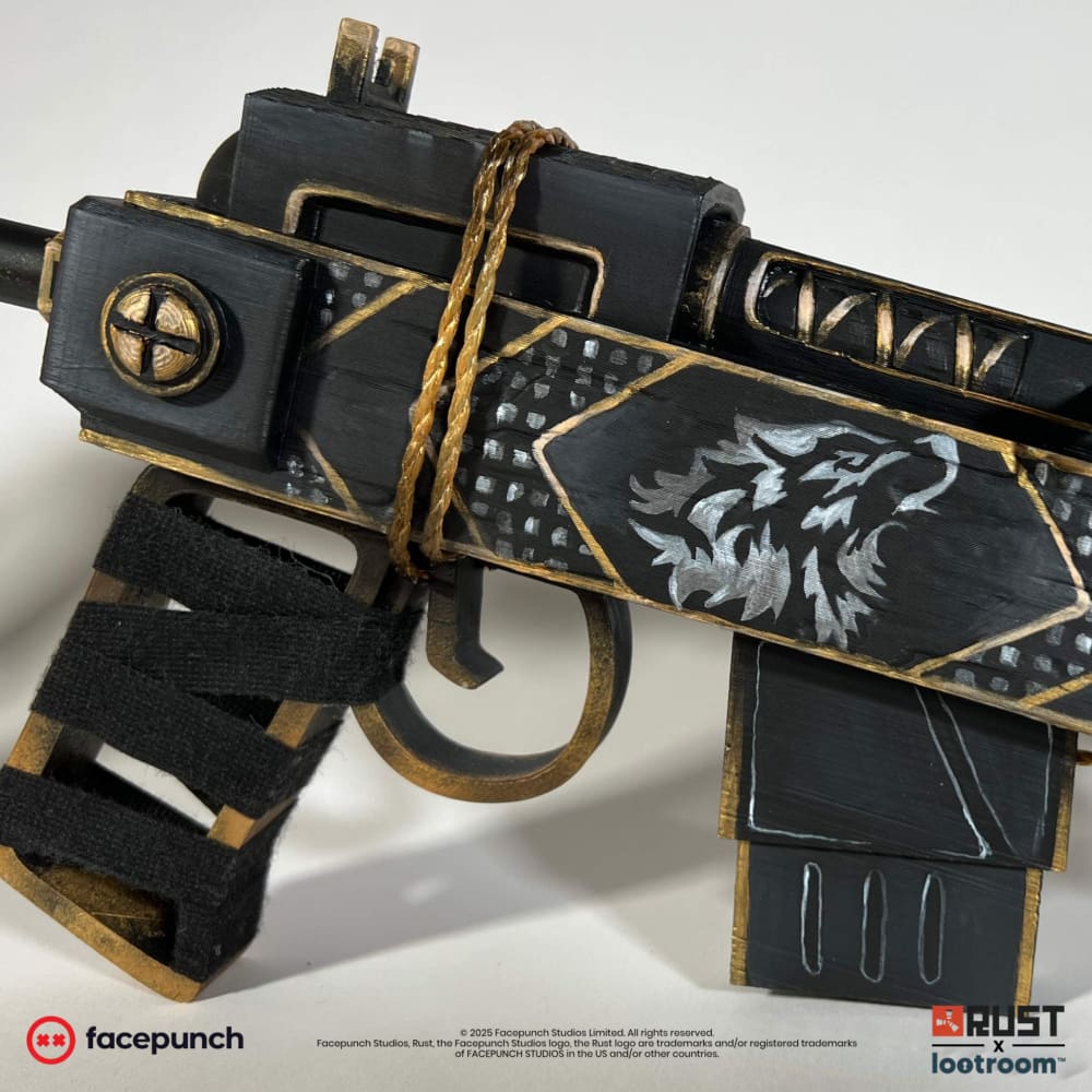 Close-up of the Rust Anthric SAR prop's receiver with the white wolf's head in its gold-framed diamond and the real gold cord.