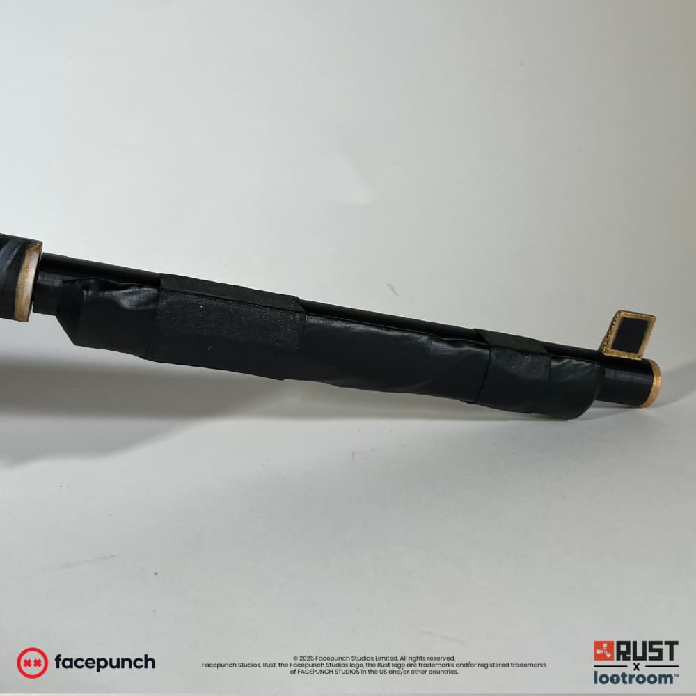 The barrel of the Rust Anthric SAR prop, wrapped in real black tape between the gold-worn muzzle end and the receiver.