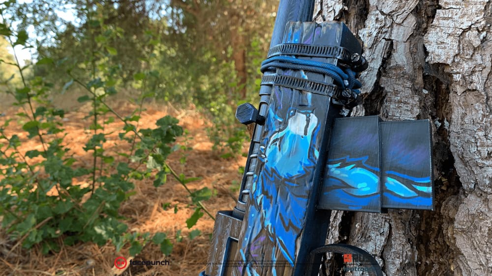 The Rust Blooprint SAR prop leaning against a tree, blue flame motifs running along the barrel.