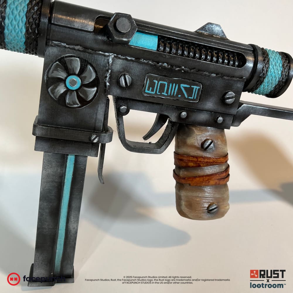 Close-up of the Rust Alien Relic SMG prop's receiver, with the rosette and the painted turquoise glyphs.