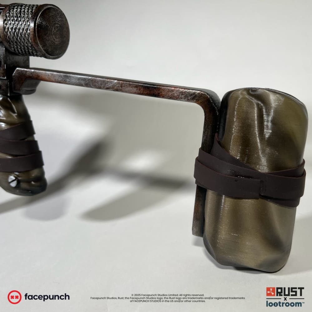 Close-up of the Rust SMG prop's olive shoulder rest, held by a brown band on the rod-look stock.