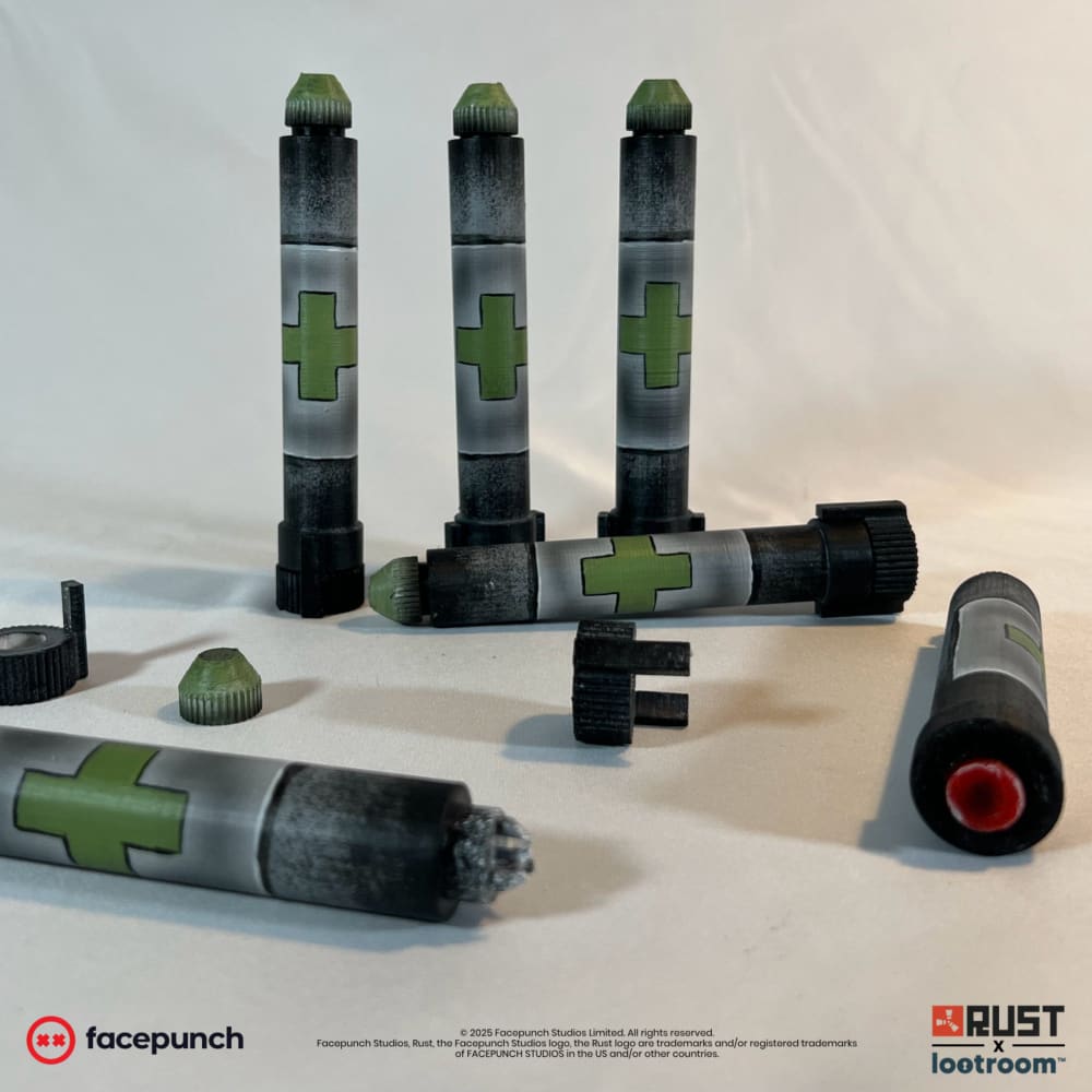 The Rust Medpen from the Solo Kit, grey barrel with a green cross and green cap, shown with further syringes
